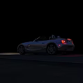 White Convertible Sports Car with Illuminated Red Taillights Parked On Dark Asphalt At Night