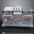 Silver Nespresso Coffee Machine With Stainless Steel Design And Coffee Cups On Top