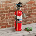 Red Fire Extinguisher On Wooden Bench Against Red Brick Wall With Matchbox And Matches
