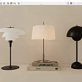 Three Modern Table Lamps With Stylish Shades Placed On Stack Of Books