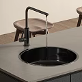 Modern Kitchen Black Sink With Water Flowing From Black Faucet On Gray Countertop