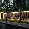 Illuminated Building Exterior Wall with Perforated Brick Design and Trees in Evening Scene with Pedestrian