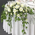 Elegant Round Dining Table With White Tablecloth Stylish Tableware And White Flower Centerpiece Green Foliage