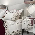 Burgundy Double Bed With Light Gray Headboard Patterned Pillows White Blanket Bedside Tables And Lamps