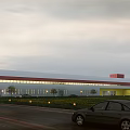 Modern Industrial Warehouse Building with Large Glass Windows Red Yellow Accents and Surrounding Greenery
