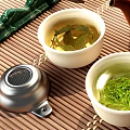 Traditional Tea Set With White Teacups Green Tea Leaves And Brown Teapot On Bamboo Mat