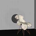 White Upholstered Accent Chair With Brass Metal Legs In Gray Textured Wall And Dark Floor
