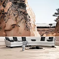 White Sectional Sofa with Black Cushions in Outdoor Rock Background Setting and Round Coffee Table