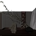 Black Ceramic Vase with Branches and Small White Flowers on Wooden Table with White Figurines