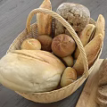 Assorted Fresh Bread Varieties With Wicker Basket And Sliced Loaf On Wooden Cutting Board