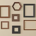 Various Shapes Brown Black Photo Frames Arranged On Beige Wall
