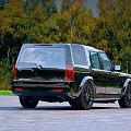 Stylish Black Land Rover SUV Parked on Stone Pavement with Autumn Forest Background