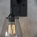 Vintage Black Metal Wall Sconces With Clear Glass Shades And Filament Bulbs On Gray Wall