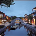 Charming Traditional Commercial Street With River Stone Bridge And Shopfront Reflections