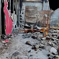 Damaged Building Interior With Collapsed Structures Broken Red Walls Debris And Wooden Fragments