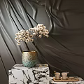 Ceramic Vase with White Dried Flowers on Marble Stand Against Dark Velvet Curtain