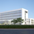Modern White Office Building With Large Glass Windows And Surrounding Trees