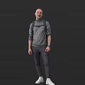 Man in Gray Turtleneck Sweater and Gray Pants with Backpack Standing Against Black Background