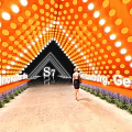 2023 S7 Event Passage Triangular Structure with Orange Lights People Standing and Green Plants