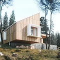 Detached Wooden House With Sloped Roof Surrounded By Trees And Stacked Wood