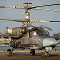 Military Helicopter With Rotors Mounted Weapons Gray Fuselage And Light Blue Nose On Ground