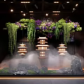 Indoor Landscape Featuring Hanging Green Vines Purple Flowers Pagoda Lanterns Mist Stones And Water Flow