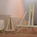 Wooden Art Easels And Canvases In Various Sizes On Wooden Floor With Light Walls