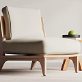 Comfortable Accent Chair with Beige Cushion Wooden Frame Beside Small Side Table Holding Green Apple