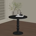 Black Round Side Table With Clear Vase Green Plant And Headphones Indoors