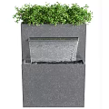 Modern Garden Accent Featuring Black Water Fountain Structure With Green Plants And Flowing Water