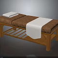Wooden Frame Massage Bed With Brown Padded Cushion White Pillow And Towel