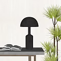 Black Table Lamp With Dome Shade Cylindrical Base On Table Near Open Book Green Plant