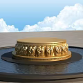 Golden Circular Sculpture Pedestal With Intricate Carved Patterns On Water Surface Against Blue Sky And Gray Floor