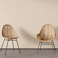 Minimalist Rattan Single Chairs with Black Metal Legs Against Beige Wall and Gray Floor