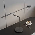 Black Modern Adjustable Arm Table Lamp With Circular Base On Black Desk