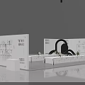 Modern Exhibition Booth Design With White Display Tables Product Racks Green Plants And Signage