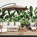 Comfortable Outdoor Sofa Set With Large Umbrella Green Tropical Plants And Wooden Coffee Table