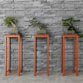 Bonsai Plants Displayed On Red Wooden Plant Stands Against Gray Brick Wall