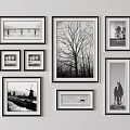 Black And White Photo Wall With Various Sized Frames Arranged On White Wall