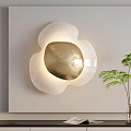 Modern Wall Lamp with White Petal Shape Gold Center and Green Plant in Living Room