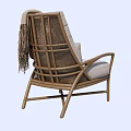 Comfortable Rattan Leisure Chair With Light Gray Cushion And Fringed Blanket For Cozy Home Use