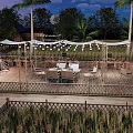 Scenic Campsite With Teepee Tents Outdoor Tables Chairs And String Lights On Wooden Deck