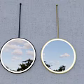 Two Decorative Wall Mirrors With Black And Yellow Frames Reflecting Blue Sky And White Clouds