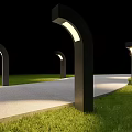 Outdoor Lights with Curved Black Posts Illuminated Tops Along Stone Path and Green Grass