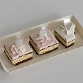 Three Layered Cakes With Pink And White Cream Decorations On Rectangular Tray