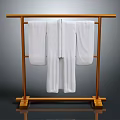 Soft White Robes Hanging On Golden Metal Clothes Rack Against Gray Background