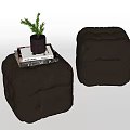 Two Dark Gray Ottoman Poufs With Magazine And Small Potted Plant On Top