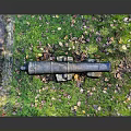 Ancient Cannon On Green Grass Field With Stones And Fallen Leaves