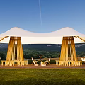 White Outdoor Tent With Wooden Support Structures Chairs Tables And Mountain View