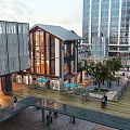 Traditional And Modern Architecture Commercial Street With Pedestrians Outdoor Seating Trees And High Rise Buildings